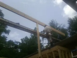 Carpenter setting a ridge beam over a new addition frame — Ice Dam Removal by Roofing Brothers in Williamsville